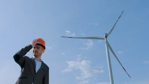 An engineer stands next to the wind generator Stock Footage 134167246