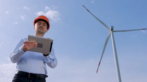 An engineer stands next to the wind generator Stock Footage 134167967