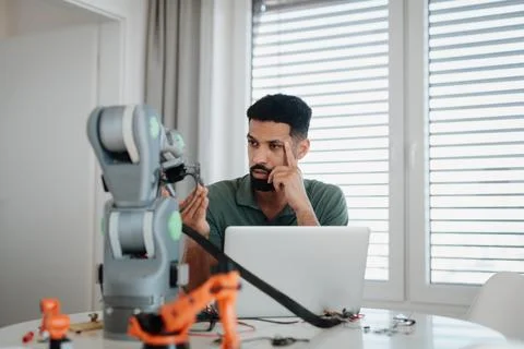 Engineer struggling with a technical problem while building robotic arm. Stockfoto's