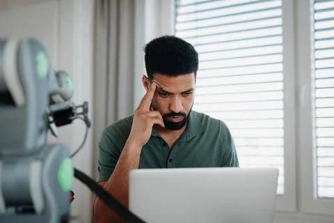 Engineer struggling with a technical problem while building robotic arm. Stockfoto's