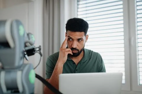 Engineer struggling with a technical problem while building robotic arm. Fotos de archivo