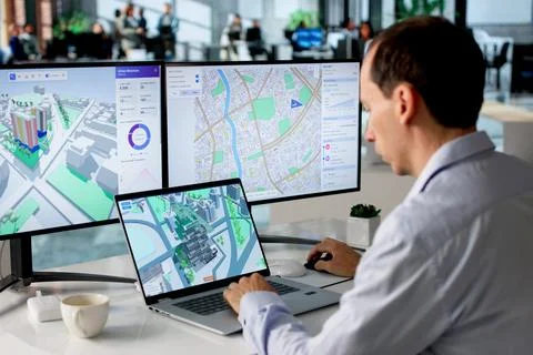 Engineer Studies Urban Property Maps On Laptop Using BIM And GIS Software. 写真素材