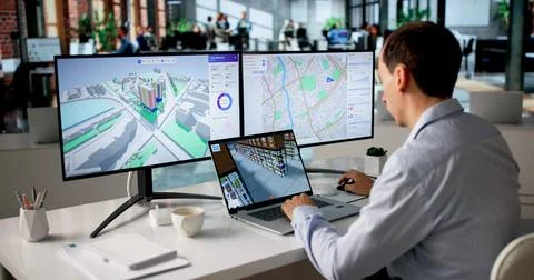 Engineer Studies Urban Property Maps On Laptop Using BIM And GIS Software. Stock Photos