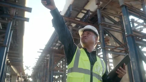A engineer supervises road construction, commands with Walkie-Talkie radio .. Stock-Footage 246350054