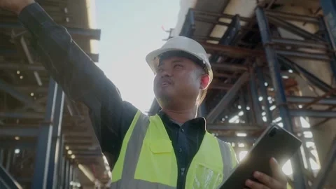 A engineer supervises road construction, commands with Walkie-Talkie radio .. Video stock 246350055