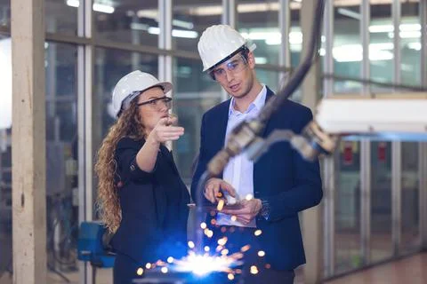 Engineer supervising autonomous producton process industry robot arm in facto 스톡 사진