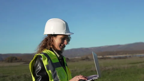 Engineer surveyor woman checking land site with laptop computer wearing hardhat Stock Footage 321062155