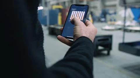 Engineer swiping through forecast analysis app on smartphone Stock Footage 132704949