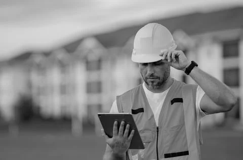 Engineer with tablet, building inspection. Construction man in helmet build new 스톡 사진