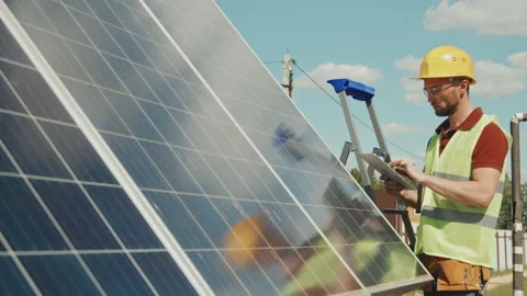 Engineer with Tablet Checking Solar Panels Stock Footage 166557995