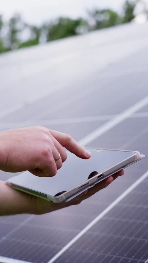 Engineer on a tablet configures the operation of solar panels. Vídeos de archivo 313234752