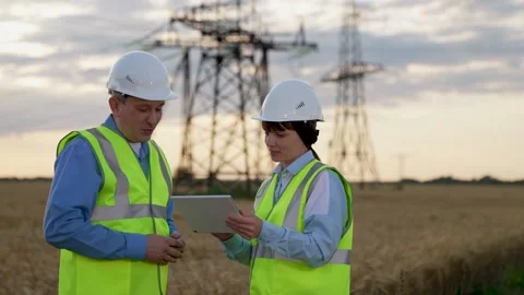 Engineer with tablet explains innovations in power distribution substation work Stock Footage 252546777