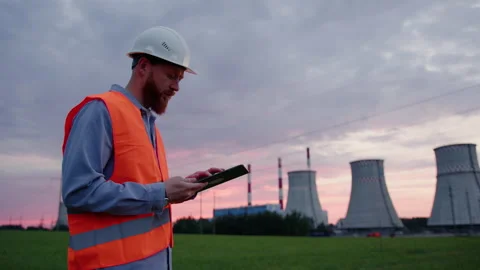 An engineer with a tablet in his hands against the background of a power plant Stock Footage 234262794