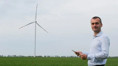 An engineer with a tablet in his hands on the background of a wind farm. Stock Footage 134163358