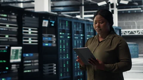 Engineer with tablet walks through data center server rows Stock Footage 317126175