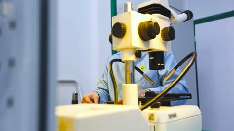 Engineer Takes Off His Glasses and Sits at a Microscope Closeup Video stock 60583136