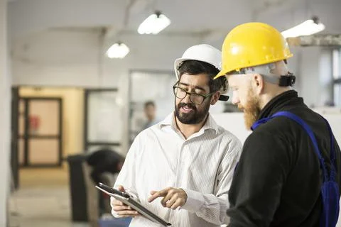 Engineer talking with construction worker Stock Photos