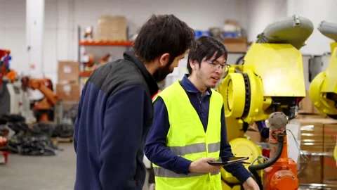 Engineer talking to employee in a factory Stock Footage 260577126