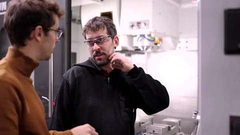 Engineer talking to a manual worker about an industrial process Stock Footage 258706514