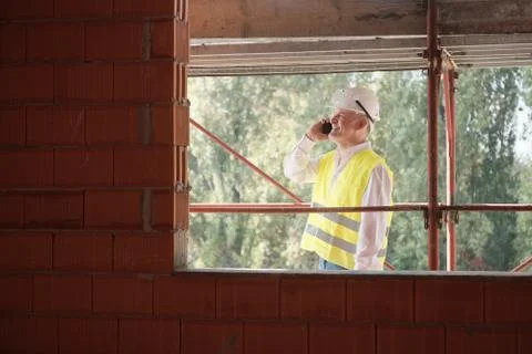 Engineer Talking On Mobile Phone In Construction Site Stock Photos