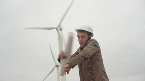 Engineer talking on phone on background of wind farm, screaming, nervous,  Video stock 118196501