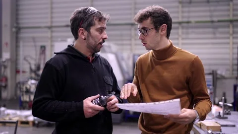 Engineer talking to a worker in a factory Video stock 258706629