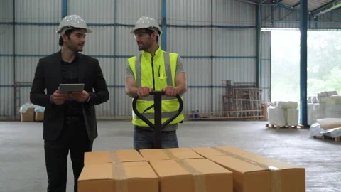 The engineer talks to the inspector to discuss how the warehouse works. Stock Footage 139653405