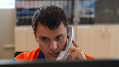 Engineer talks on phone working on computer in control room 스톡 동영상 156317853