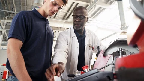 Engineer Teaching Apprentice How To Use Machine In Factory Stock Footage