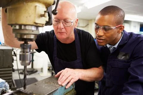 Engineer teaching apprentice to use milling machine Foto stock