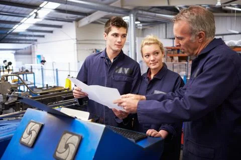 Engineer teaching apprentices to use tube bending machine Stock Photos