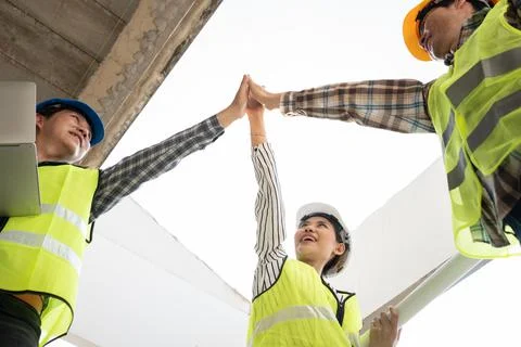 Engineer team and contractor raise their hands up together for joining hands  Stock Photos