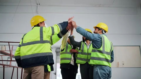 Engineer, team and high five at site for construction, motivation and success of Stock Footage 341578959