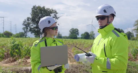 Engineer team discussing project using laptop and radio communication near wind Stock Footage 335218368