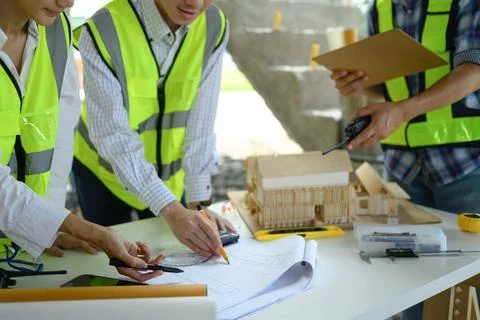 Engineer team having briefing about project reviewing blueprints at a building Fotos de archivo
