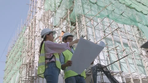 Engineer team planning and looking on blue print in construction site Stock Footage 150564340