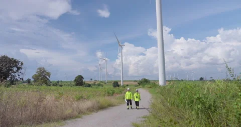 Engineer team walking through wind turbine area analyzing project plan teamwork Stock Footage 337161914