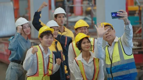 Engineer team wearing helmet using smartphone to take a selfie group at factory Видео 237007773