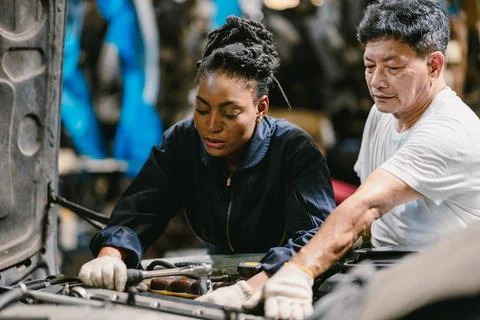 Engineer team working together helping fix service broken car. Women mechan.. 스톡 사진