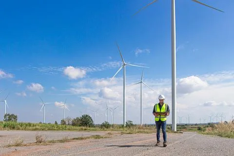 Engineer team working in wind turbine farm. Renewable energy with wind genera Stock Photos