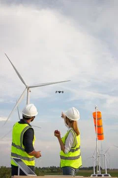 Engineer team working in wind turbine farm. Renewable energy with wind genera Stock Photos