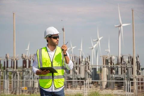 Engineer team working in wind turbine farm. Renewable energy with wind genera Stock Photos