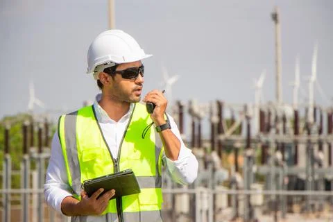 Engineer team working in wind turbine farm. Renewable energy with wind genera Stock Photos