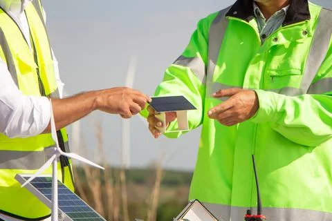Engineer team working in wind turbine farm and solar cell. Renewable energy with Stock Photos