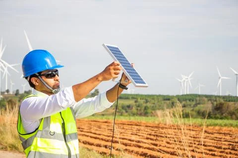 Engineer team working in wind turbine farm and solar cell. Renewable energy with Stock Photos