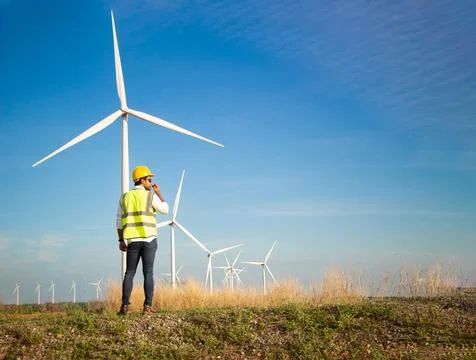 Engineer team working in wind turbine farm. Renewable energy with wind genera Stock Photos