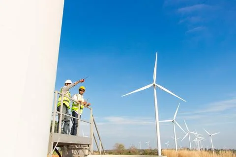 Engineer team working in wind turbine farm. Renewable energy with wind genera Stock Photos
