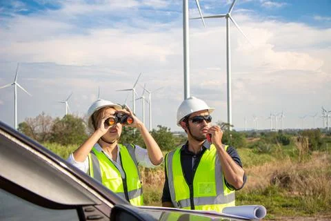 Engineer team working in wind turbine farm. Renewable energy with wind genera Stock Photos