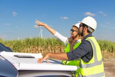 Engineer team working in wind turbine farm. Renewable energy with wind genera Stock Photos
