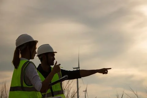 Engineer team working in wind turbine farm. Renewable energy with wind genera Stock Photos